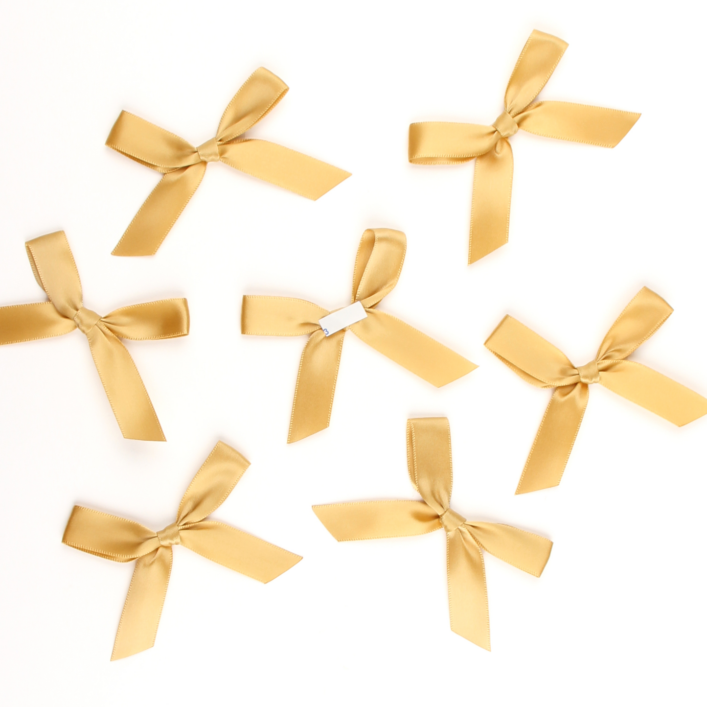 Multiple gold satin pre-tied bows by Lux Party, showing peel and stick backing.