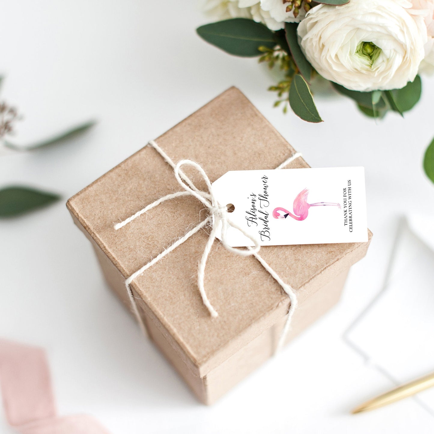 Lux Party’s white flamingo bridal shower favor tag with black lettering, tied to a brown kraft favor box.
