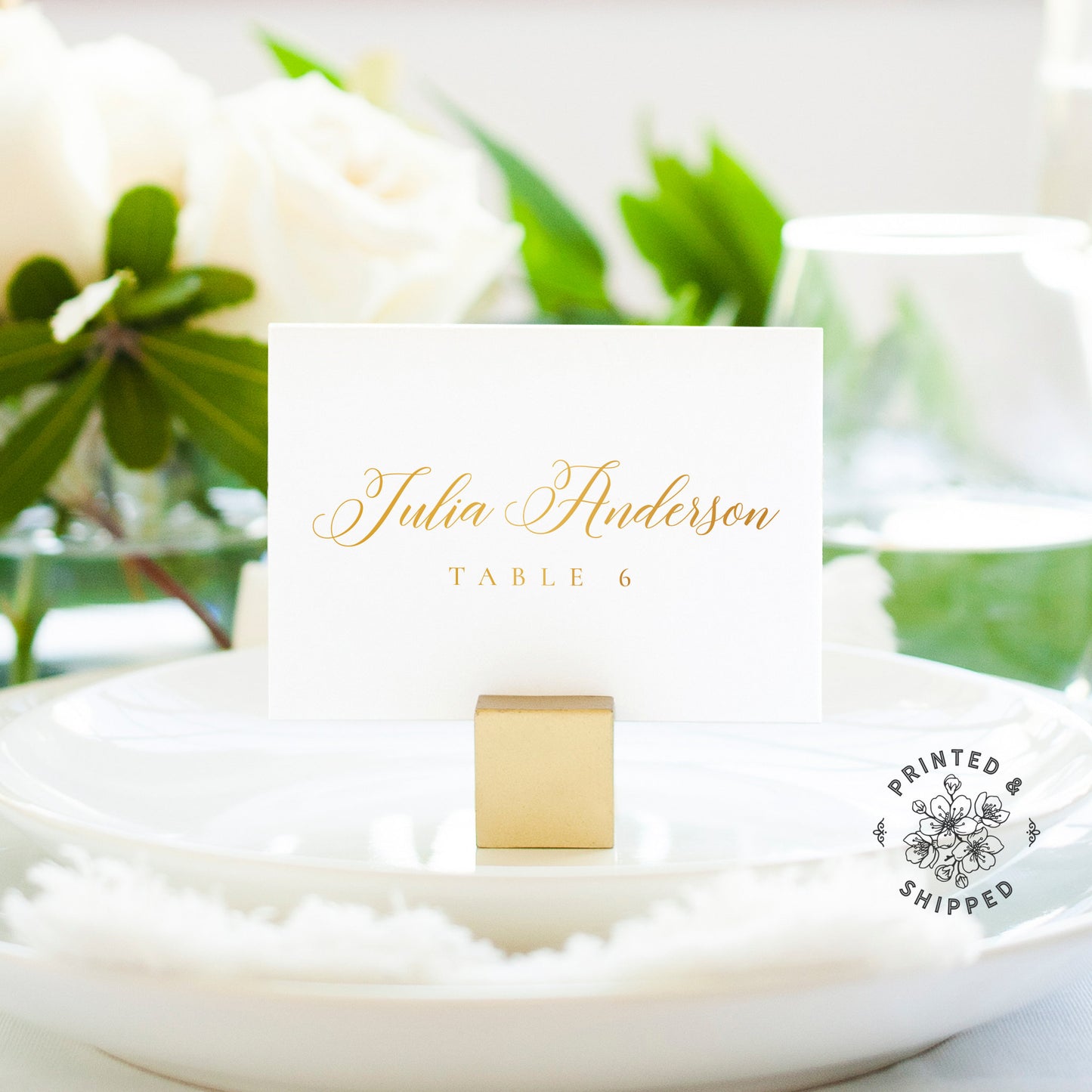 Lux Party’s gold place cards with white background and gold lettering, in a wedding table place setting.
