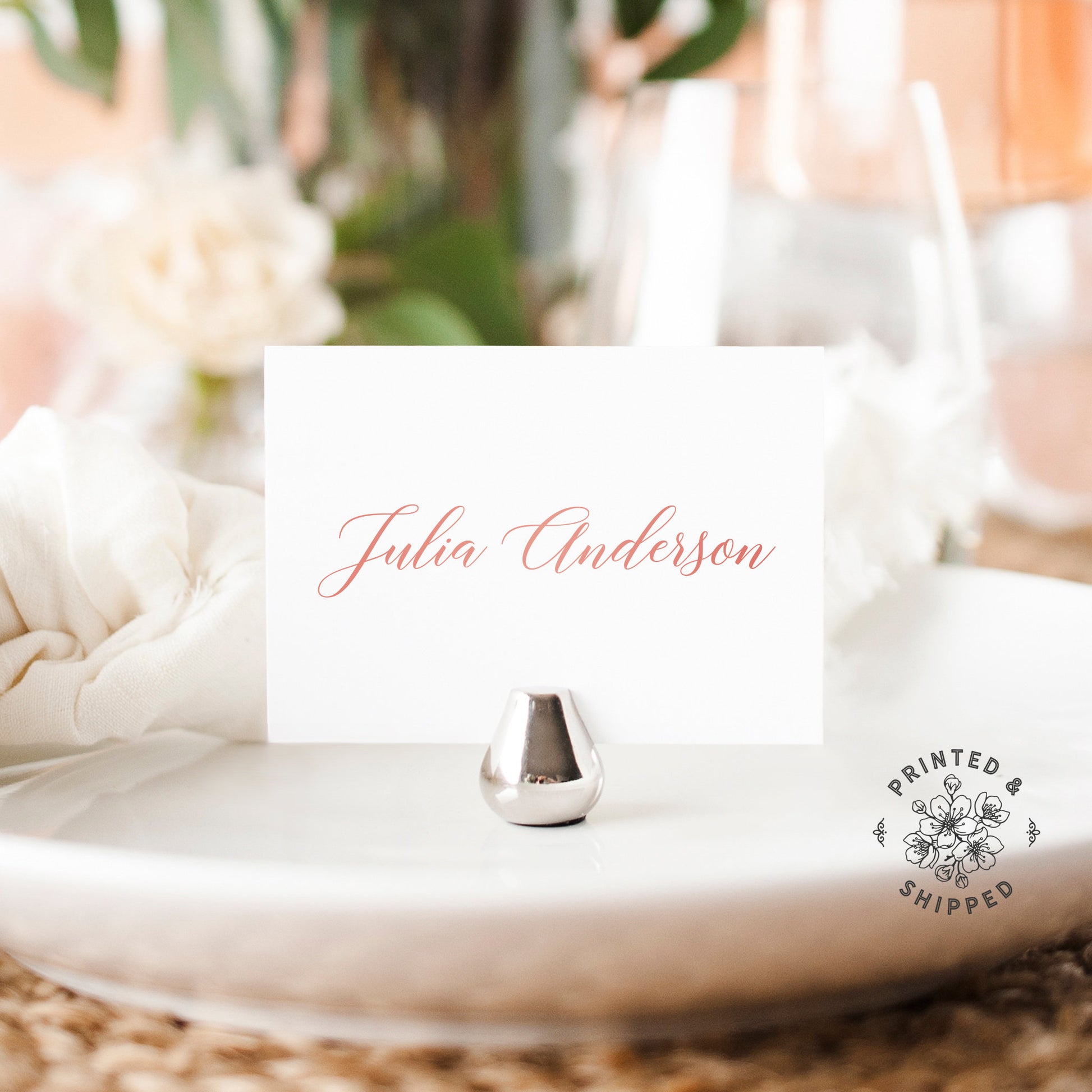 Lux Party’s rose gold place cards with white background and pink lettering, in a wedding table place setting.