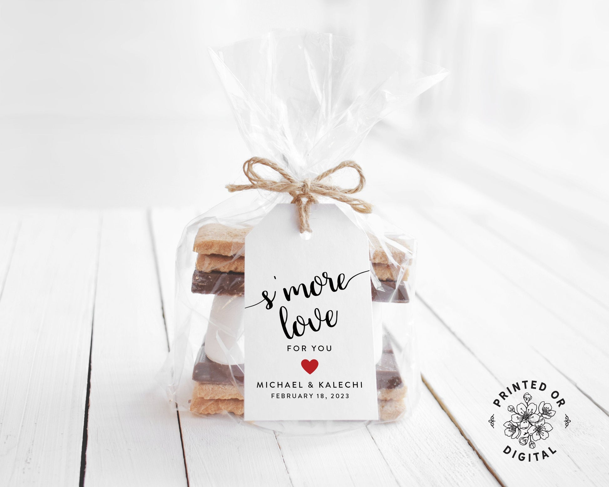Lux Party’s white s’more love wedding favor tag with black script and a red heart, tied to a clear favor bag of s’mores ingredients.